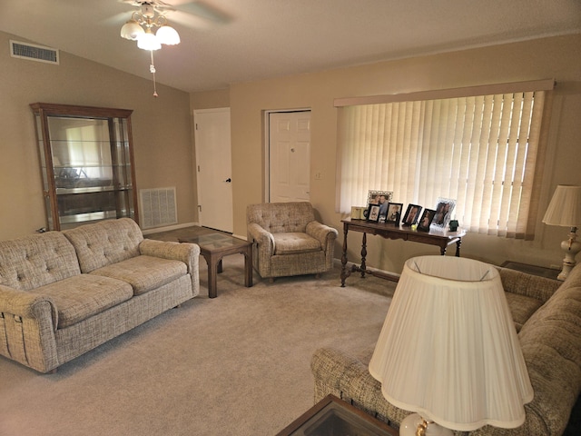 carpeted living area with lofted ceiling, ceiling fan, visible vents, and baseboards