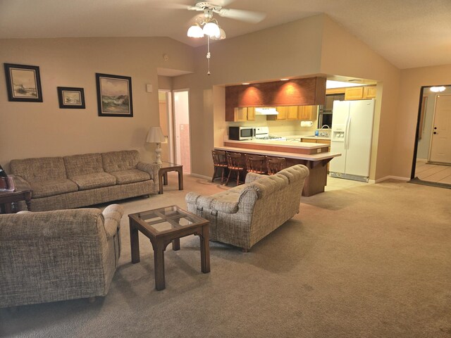 living room with ceiling fan with notable chandelier, carpet floors, vaulted ceiling, and wet bar