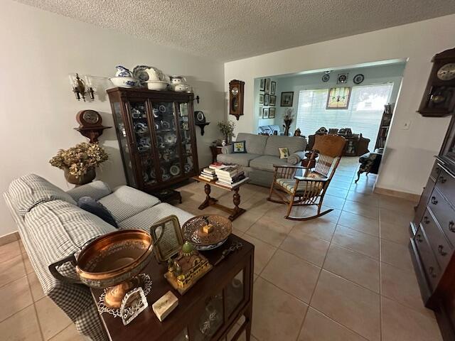 living room featuring a textured ceiling and tile patterned floors