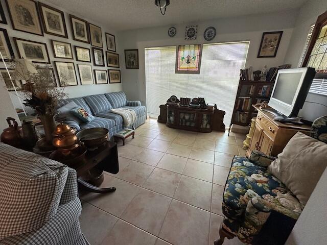 living room with plenty of natural light, light tile patterned floors, and a textured ceiling