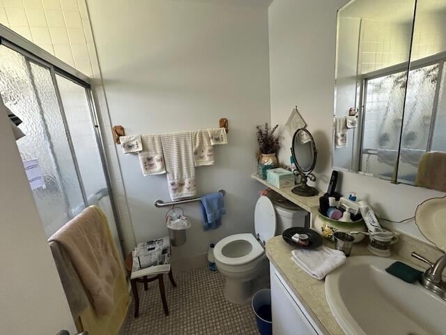 bathroom featuring tile patterned floors, vanity, toilet, and walk in shower