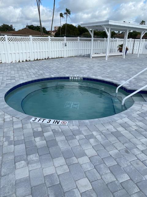 view of swimming pool with a patio and a hot tub