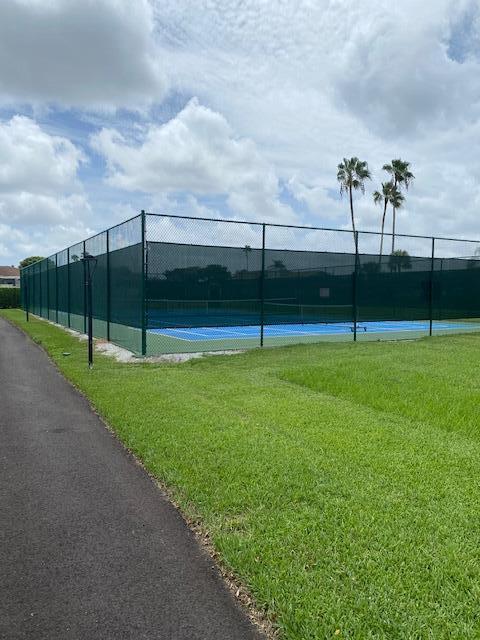 view of tennis court with a lawn