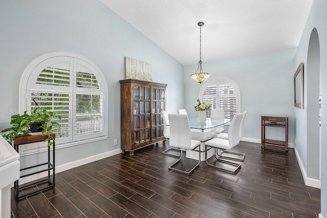 dining space featuring a textured ceiling, dark hardwood / wood-style flooring, and high vaulted ceiling