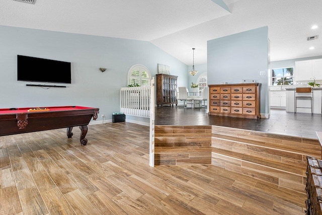 rec room with baseboards, visible vents, vaulted ceiling, and light wood finished floors