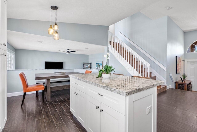 kitchen featuring white cabinets, dark hardwood / wood-style flooring, hanging light fixtures, and a textured ceiling