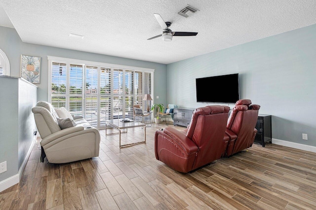 living room featuring hardwood / wood-style floors, a textured ceiling, and ceiling fan