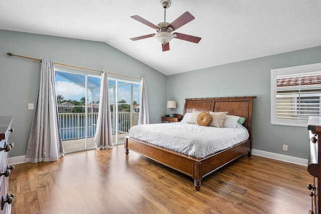 bedroom with ceiling fan, hardwood / wood-style floors, a textured ceiling, vaulted ceiling, and access to outside