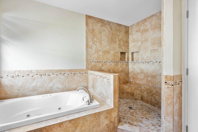 bathroom featuring tile walls and independent shower and bath