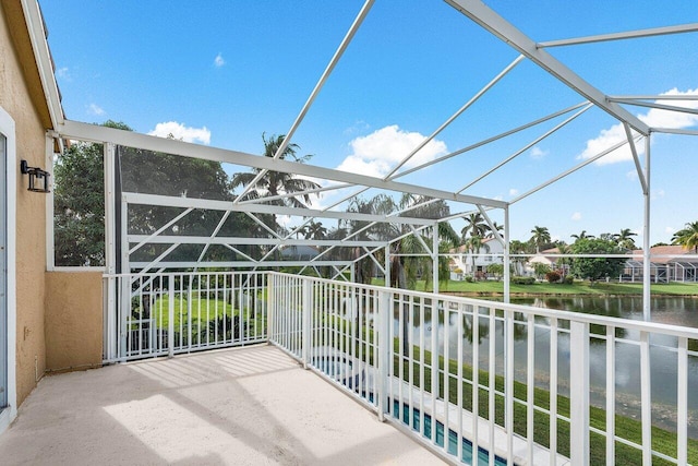 exterior space featuring a water view and glass enclosure