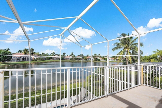 view of patio with a water view and glass enclosure