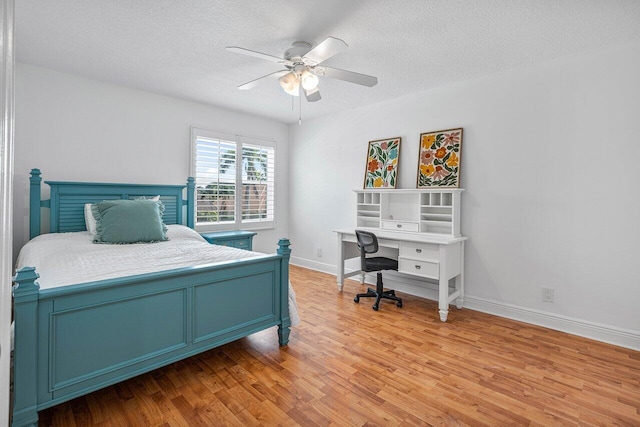 bedroom with a textured ceiling, hardwood / wood-style flooring, and ceiling fan