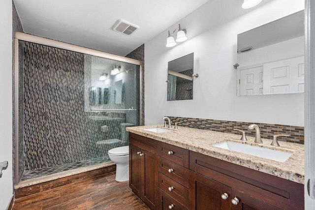 bathroom with backsplash, vanity, a shower with door, wood-type flooring, and toilet