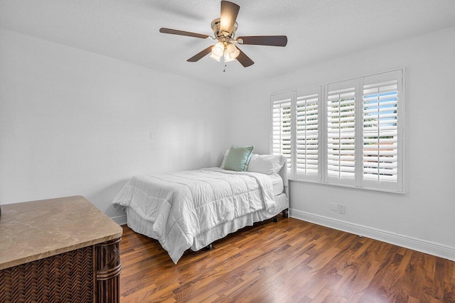 bedroom with ceiling fan, dark hardwood / wood-style floors, and a textured ceiling