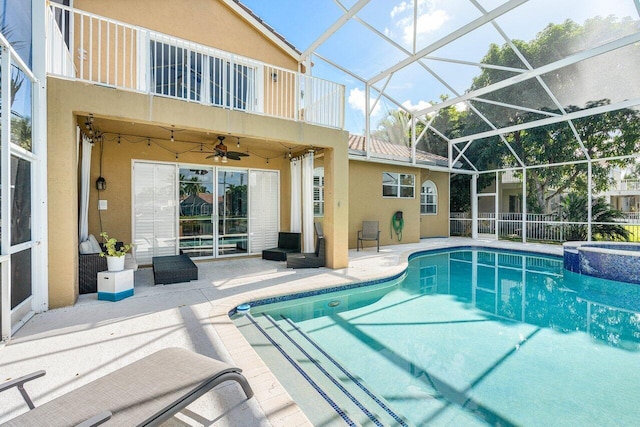 view of pool with ceiling fan, a patio area, a lanai, and a pool with connected hot tub