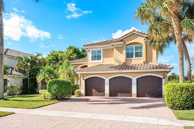 mediterranean / spanish-style house with a front lawn and a garage