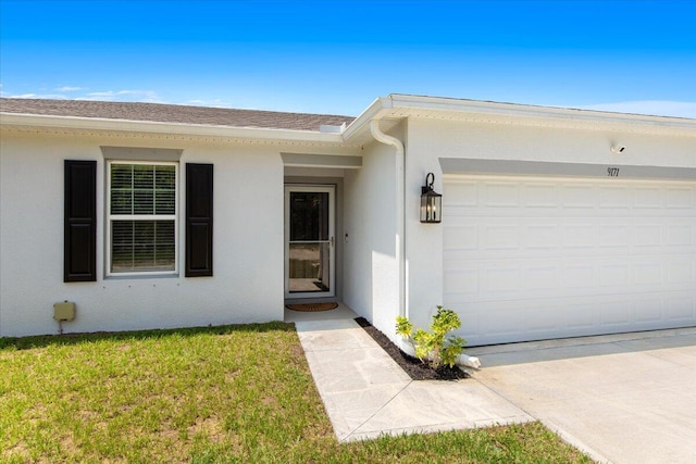 view of exterior entry featuring a garage and a yard