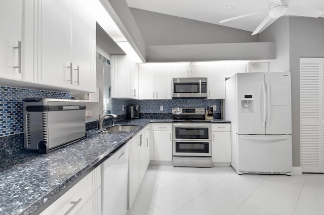 kitchen with backsplash, white cabinets, sink, vaulted ceiling, and appliances with stainless steel finishes