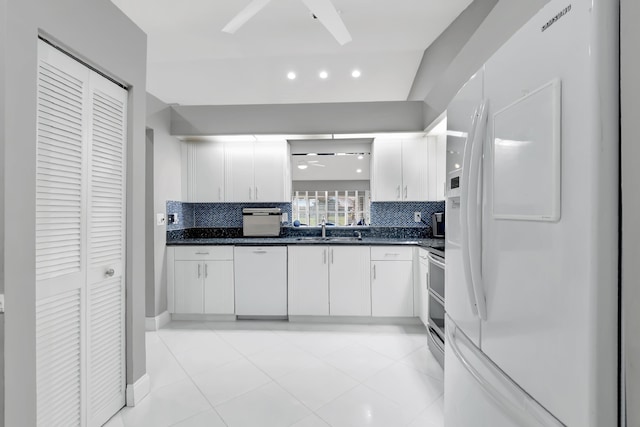 kitchen with white cabinets, backsplash, white appliances, and sink