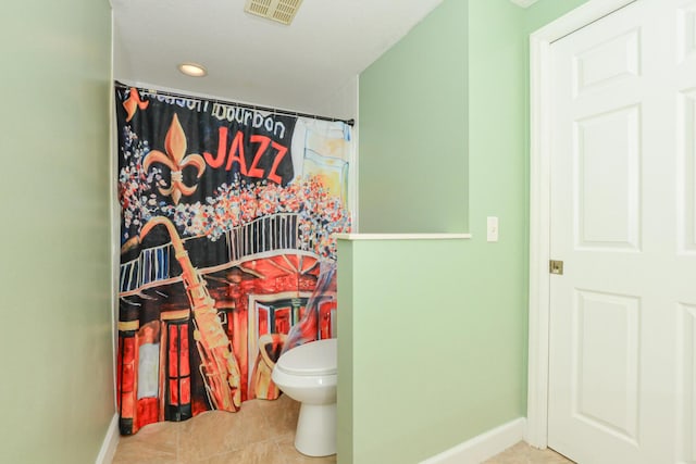 bathroom with tile patterned flooring, toilet, and walk in shower