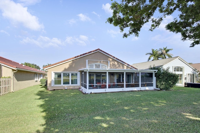 back of property with a lawn and a sunroom