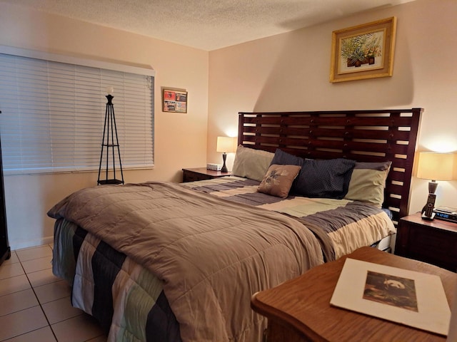 bedroom featuring light tile patterned floors and a textured ceiling