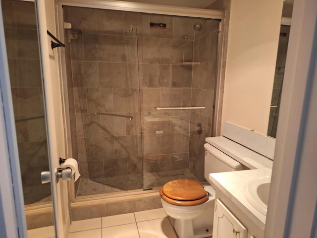 bathroom featuring tile patterned flooring, vanity, toilet, and walk in shower