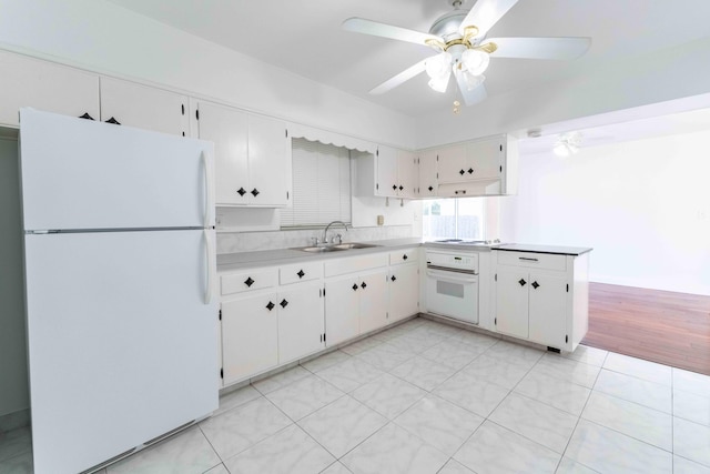 kitchen with white cabinetry, white appliances, and sink