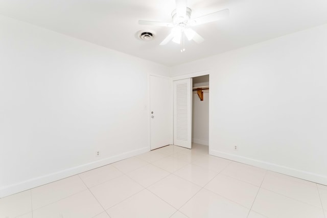 tiled spare room featuring ceiling fan