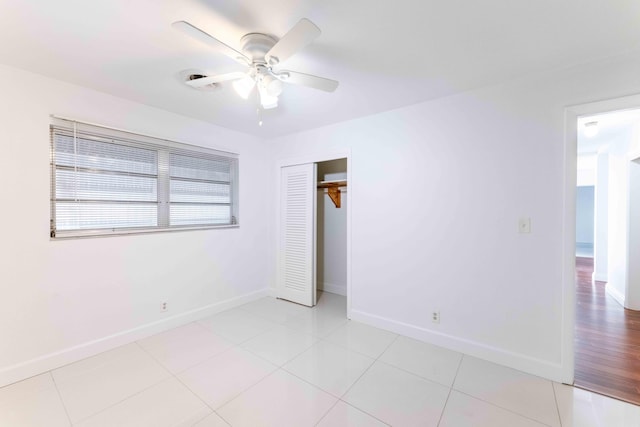 empty room with ceiling fan and light tile patterned floors