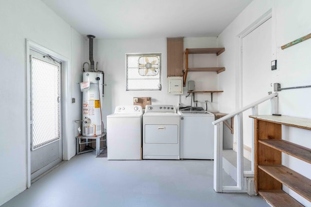 clothes washing area featuring water heater, washer and clothes dryer, and a healthy amount of sunlight