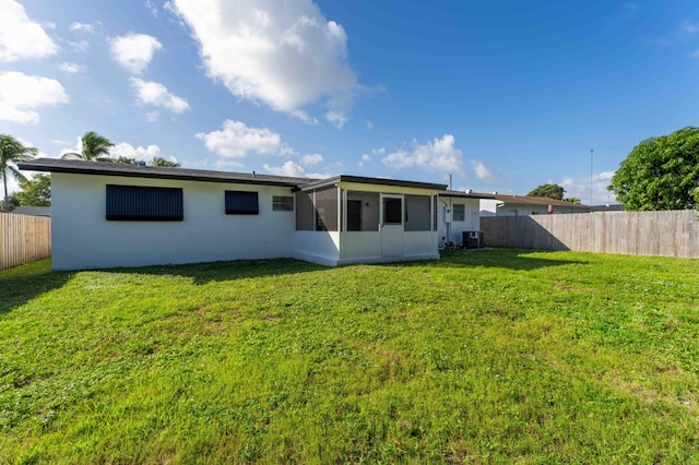 back of house with cooling unit and a yard