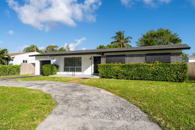 single story home featuring a front yard and a garage