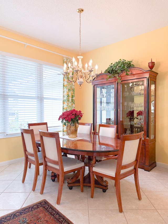 dining area with light tile patterned flooring, a textured ceiling, and a notable chandelier