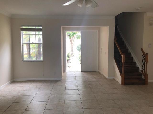 tiled entryway with plenty of natural light, ornamental molding, and ceiling fan