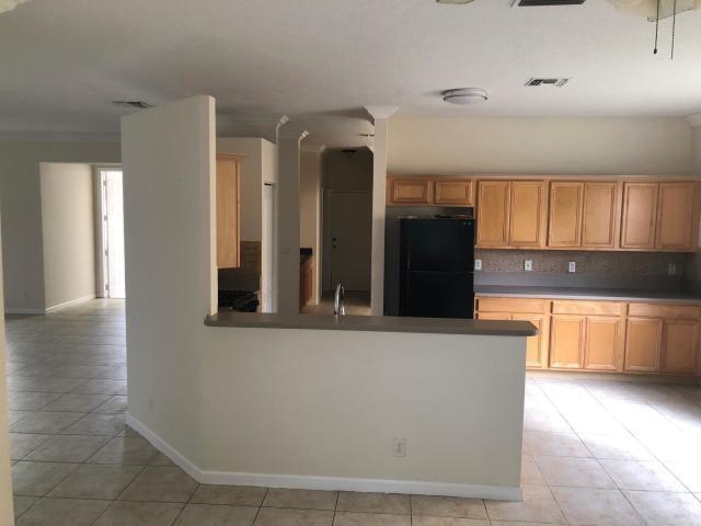 kitchen featuring backsplash, black fridge, sink, and light tile patterned flooring