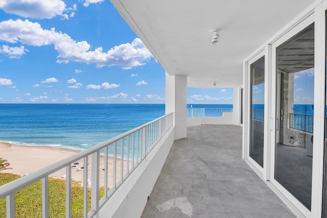 balcony featuring a water view and a beach view