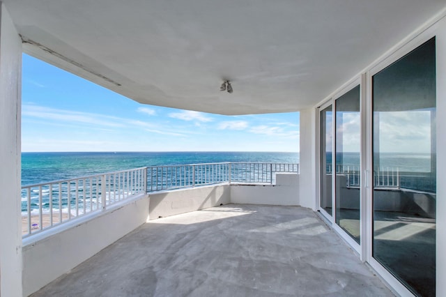 balcony with a water view and a beach view