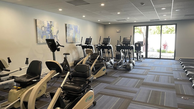 workout area featuring carpet and a drop ceiling