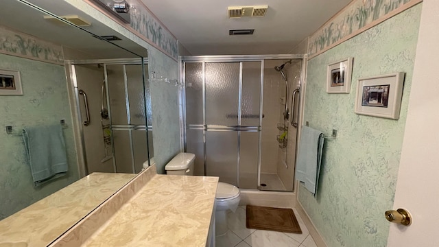 bathroom featuring tile patterned floors, vanity, toilet, and walk in shower