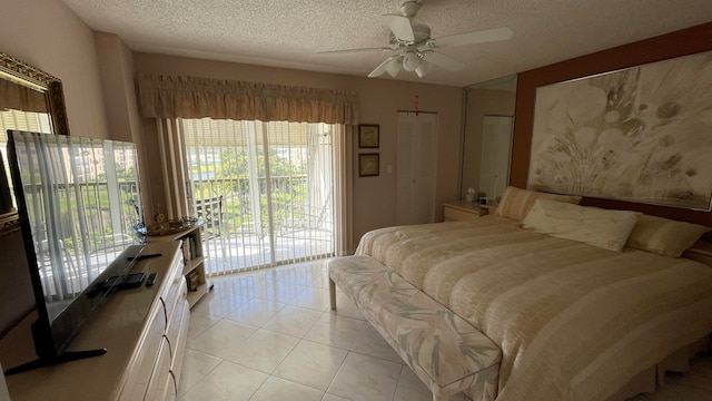 tiled bedroom featuring a textured ceiling, a closet, access to outside, and multiple windows