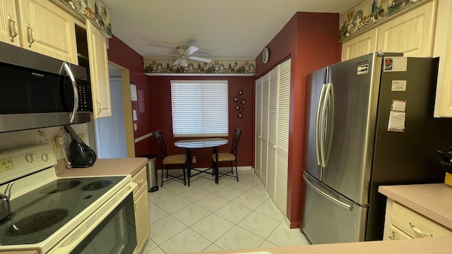 kitchen featuring ceiling fan, light brown cabinets, light tile patterned floors, and stainless steel appliances