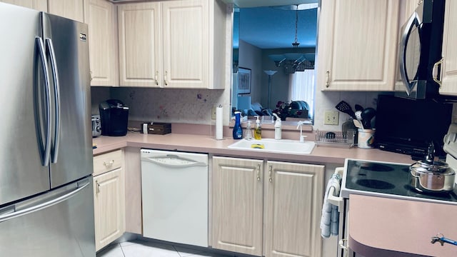 kitchen featuring appliances with stainless steel finishes, backsplash, sink, decorative light fixtures, and light tile patterned flooring