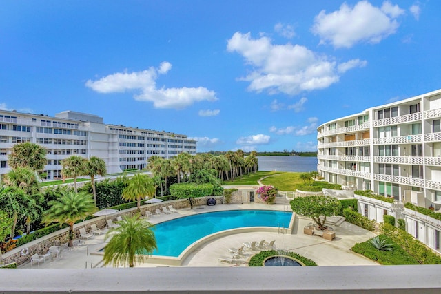 view of pool with a water view and a patio