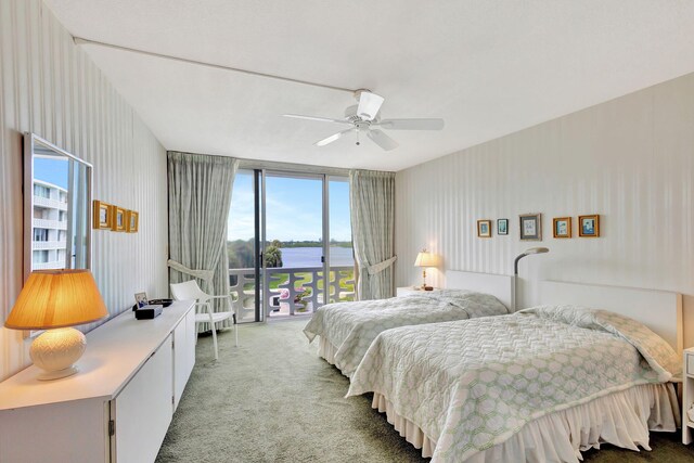 bedroom featuring carpet flooring, ceiling fan, a water view, and access to exterior