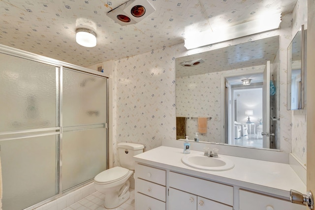 bathroom with toilet, vanity, tile patterned floors, and a shower with shower door