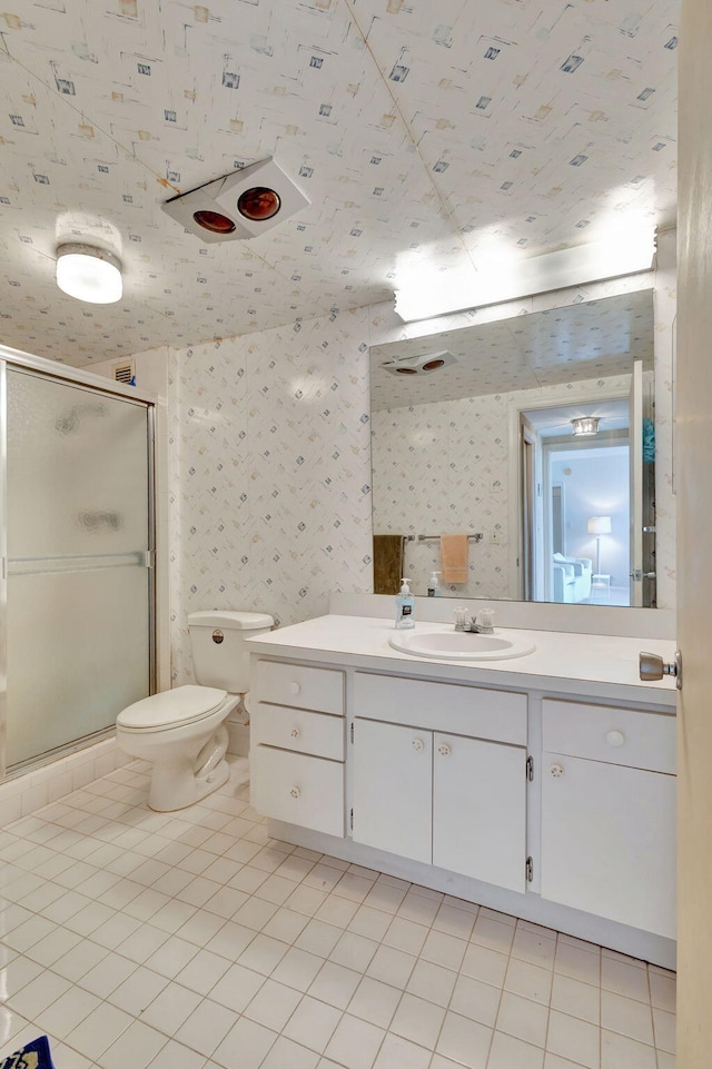 bathroom featuring tile patterned flooring, a shower with door, vanity, and toilet