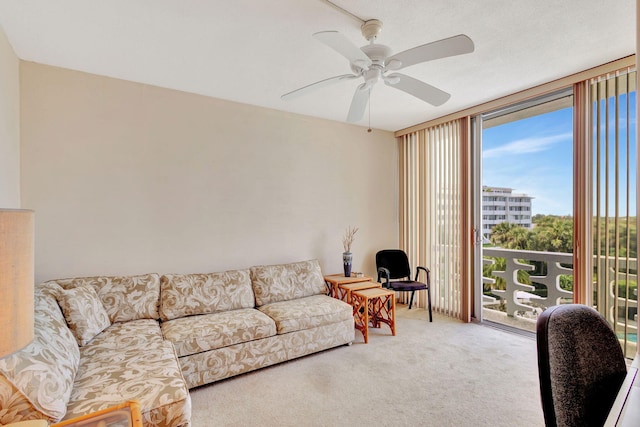 carpeted living room with ceiling fan and expansive windows