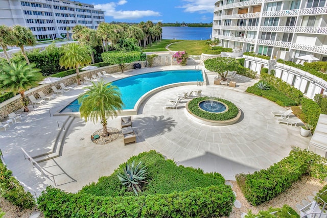 view of swimming pool featuring a water view and a patio