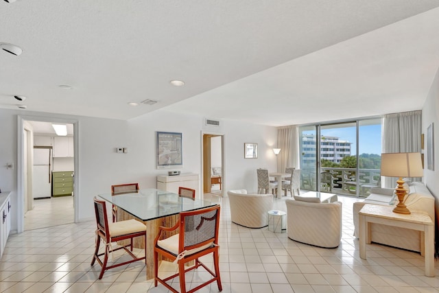 dining area with light tile patterned floors and a textured ceiling